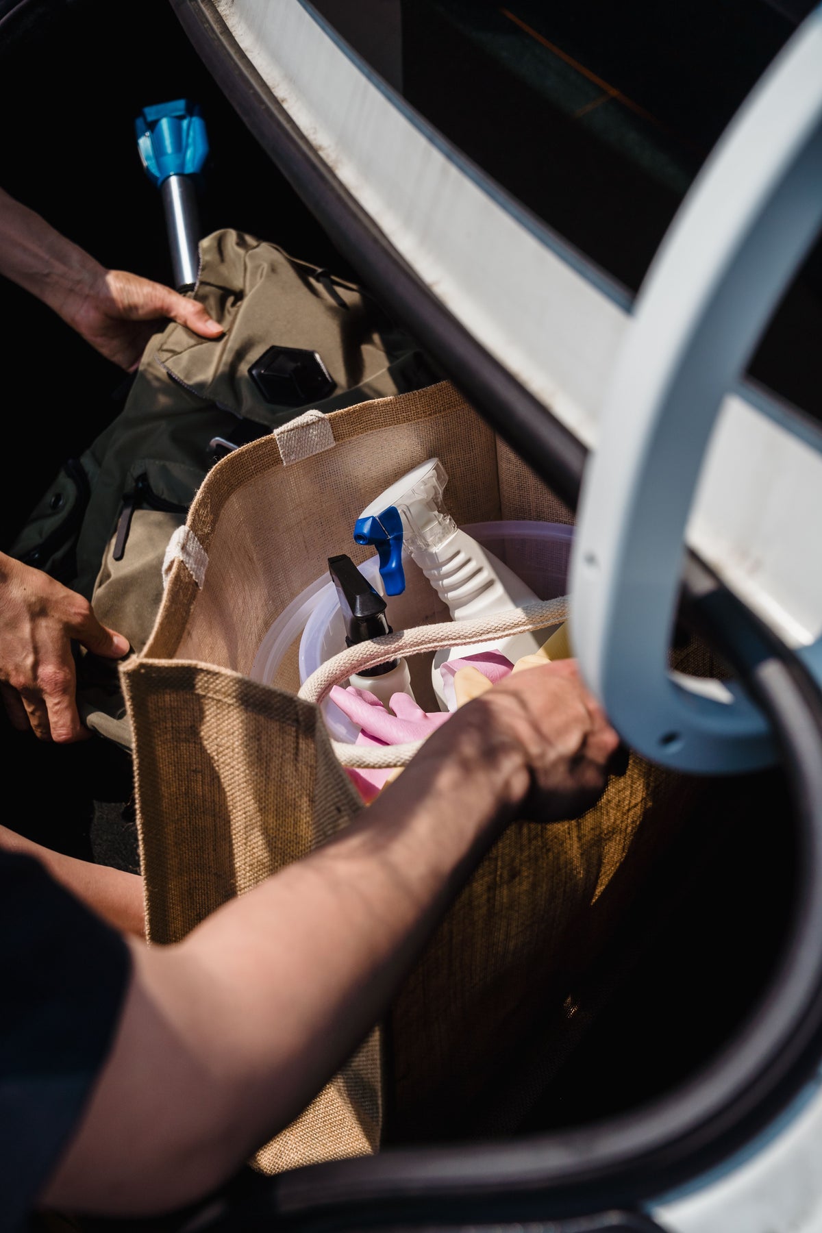 Packing supplies into an organizer box in a car trunk