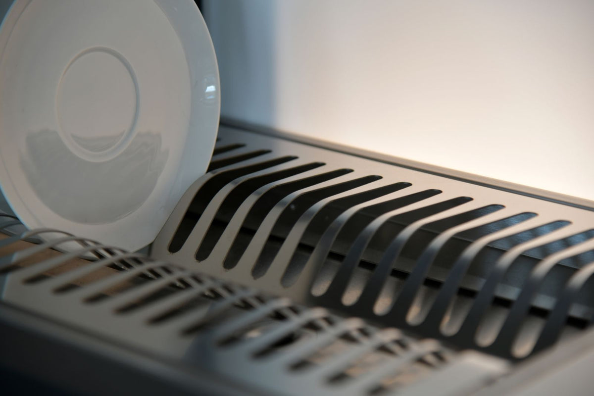 Stainless steel dish drying rack holding clean plates