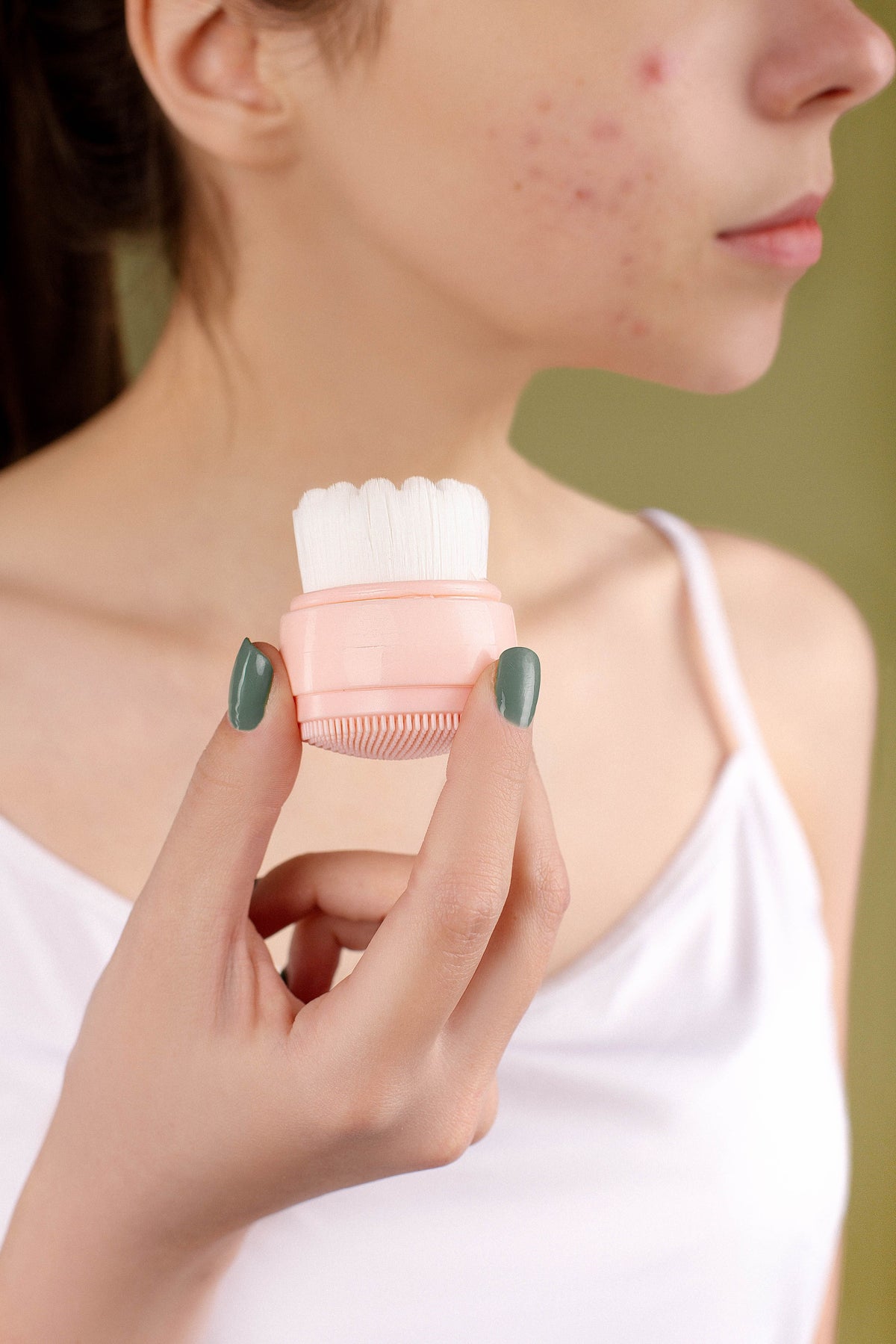 Hand holding a soft silicone facial cleansing brush