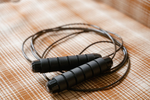 Adjustable speed jump rope with foam handles coiled up