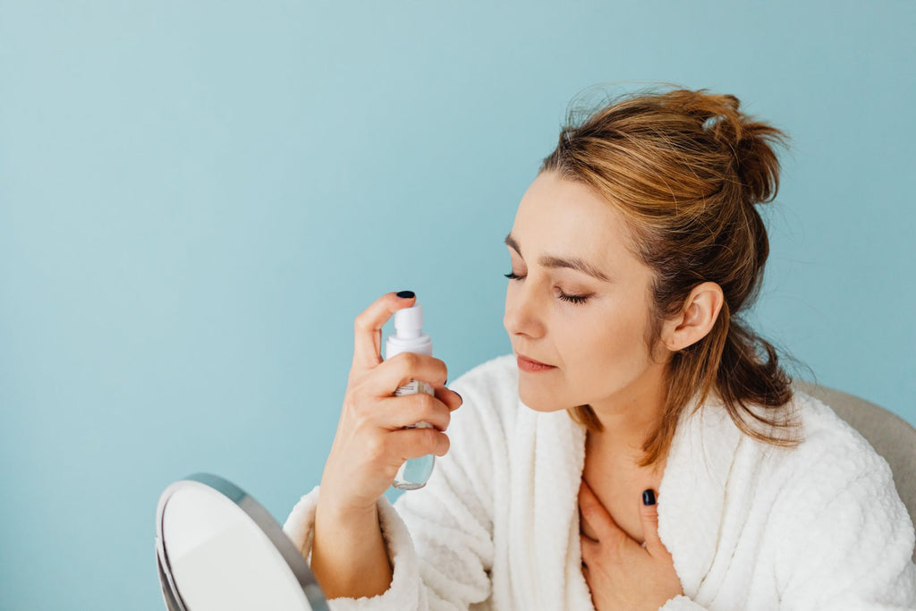 Woman spraying facial mist toner on her face