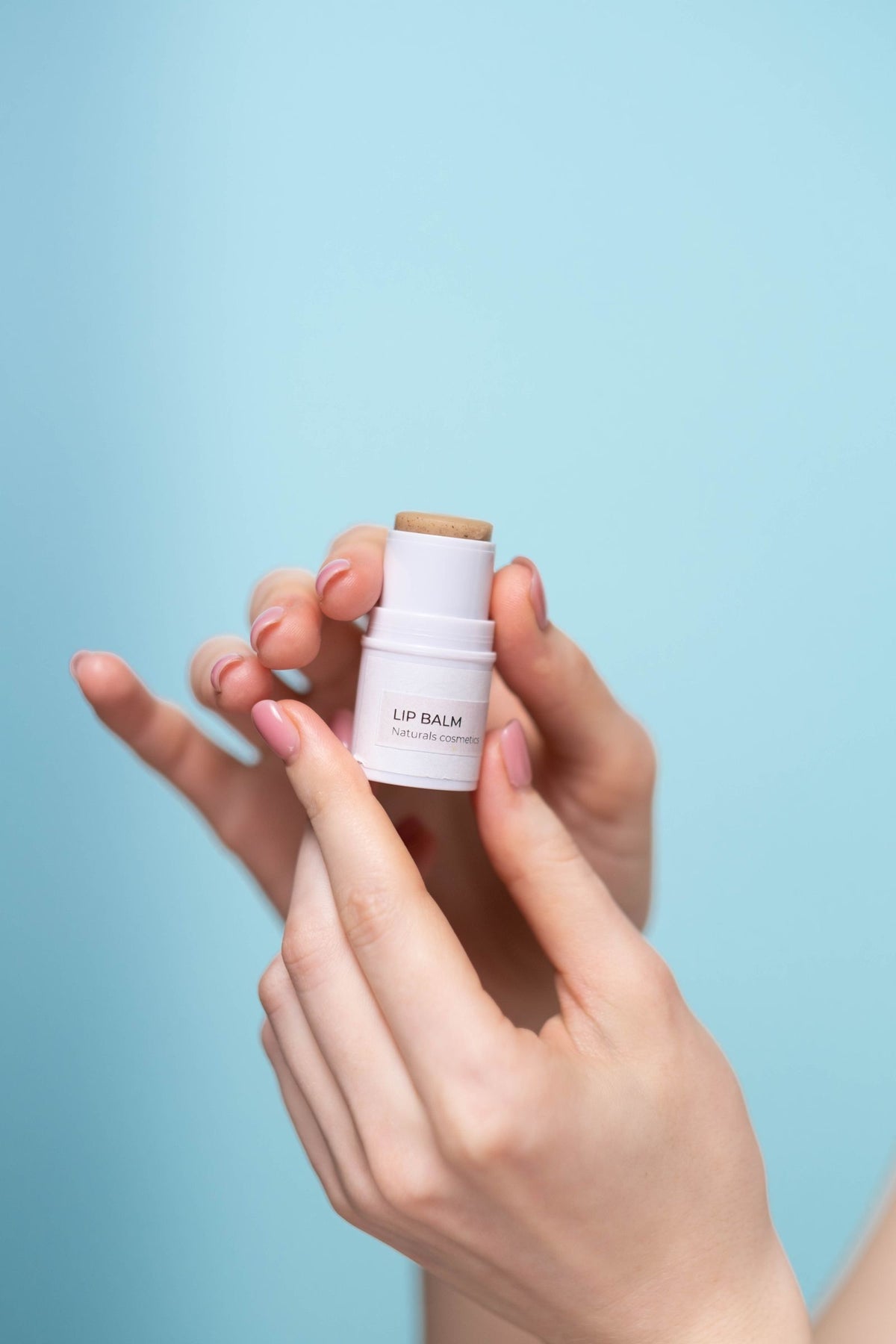 Hand holding a natural lip balm stick