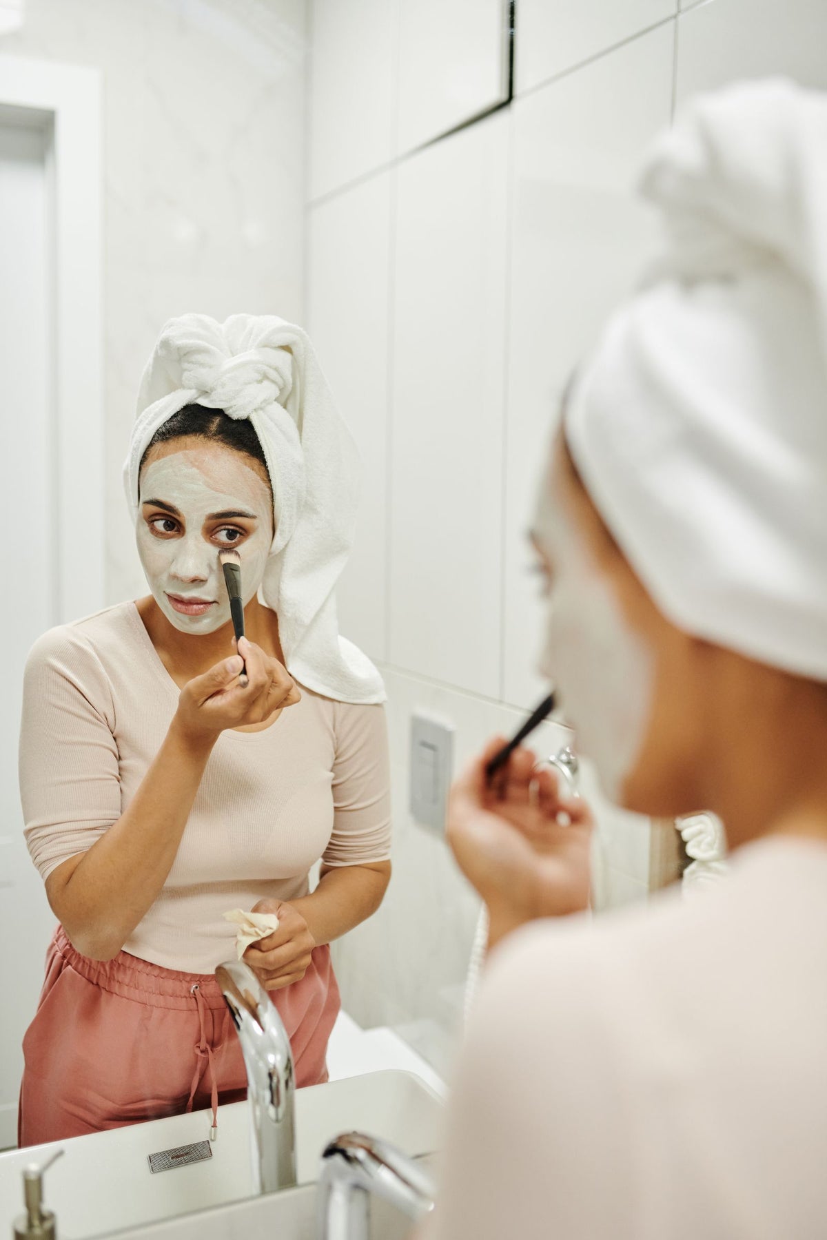 Woman using a facial cleansing brush skincare routine