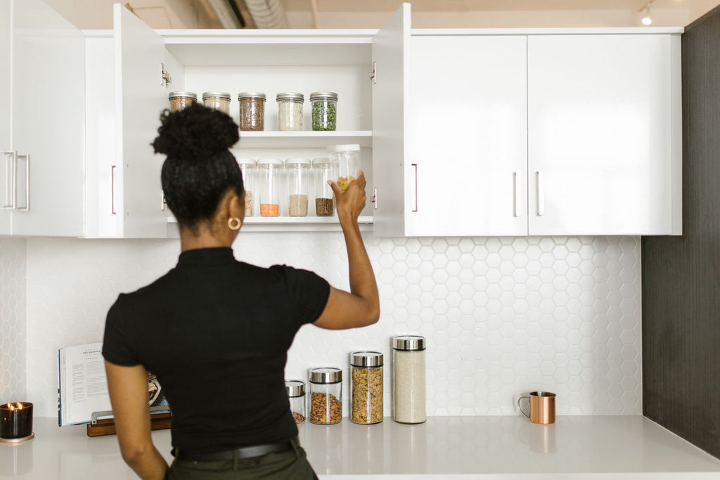 Woman organizing pantry shelf with containers