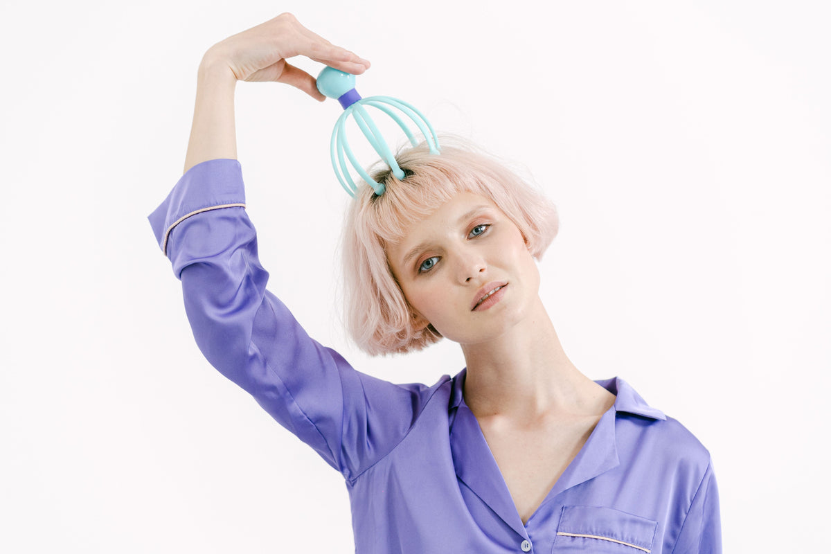 Woman using a silicone scalp massager on her head