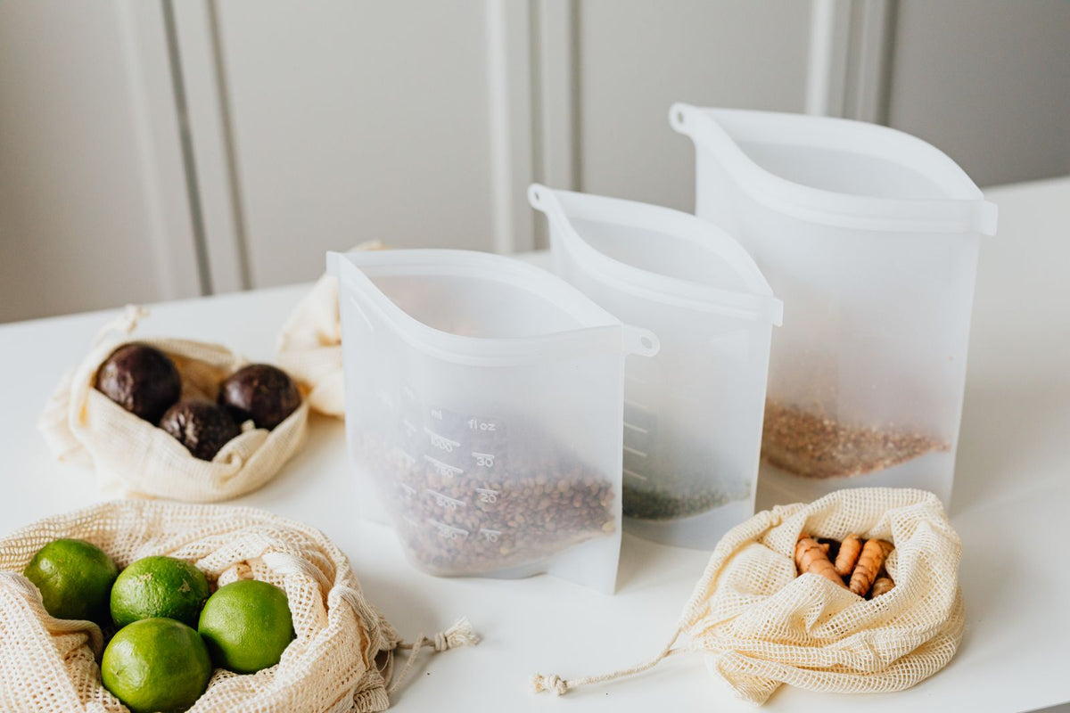 Set of reusable silicone food storage bags filled with grains and produce