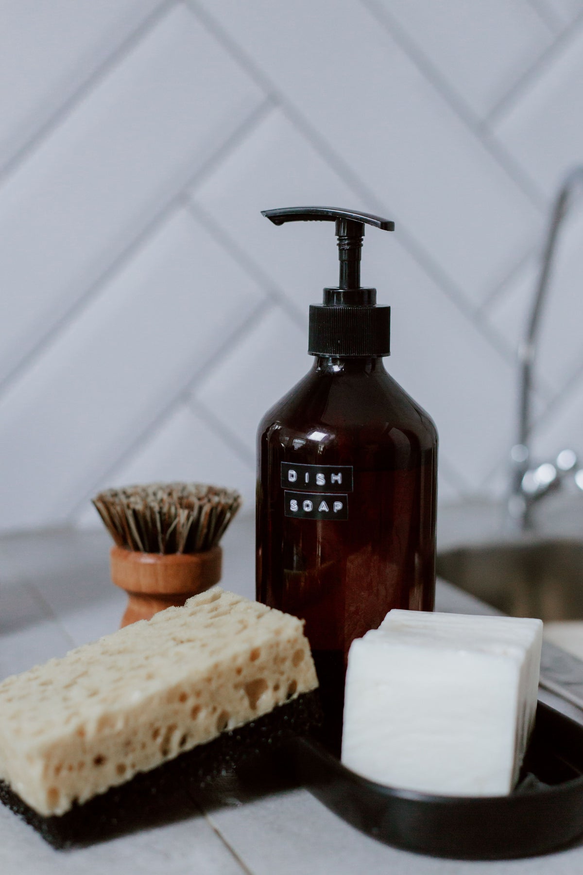 Dish soap and scrub brushes stored upright in a sink-side caddy