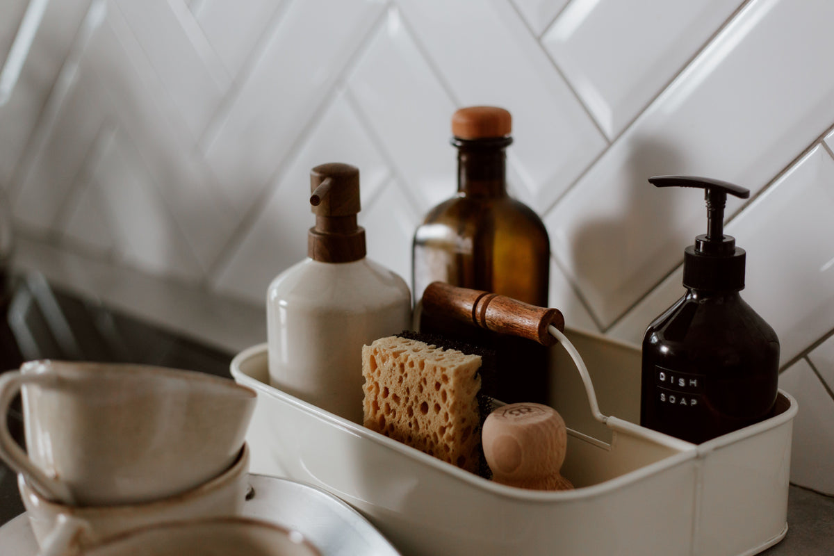 Sink-side caddy tray holding sponge, scrub brush and soap bottles